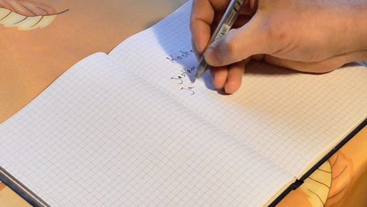 Man Writing on Notepad