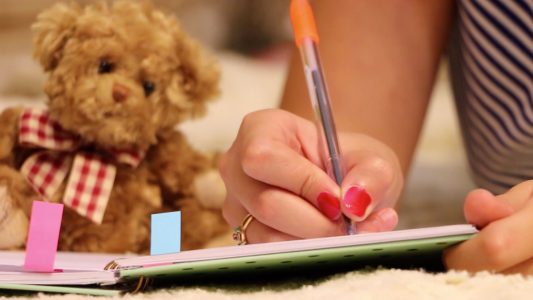 Woman Writing in Notepad