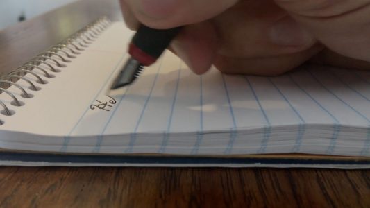 Man Writing on Notepad