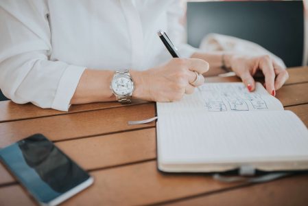 Woman Writing on a Notepad