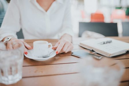 Woman Drinking Coffee with Notepad