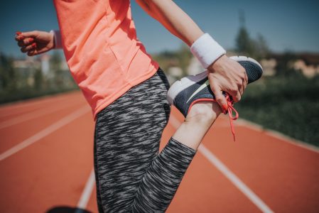 Woman Stretching On Track Field