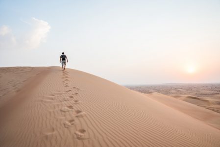 Man Walking Up Sand Dunes