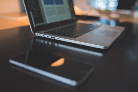 Laptop Computer & iPhone on Black Desk