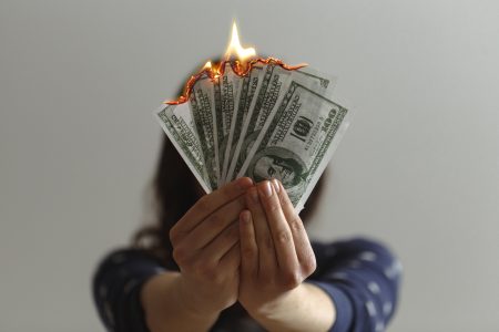 Hand Holding Bills on Fire